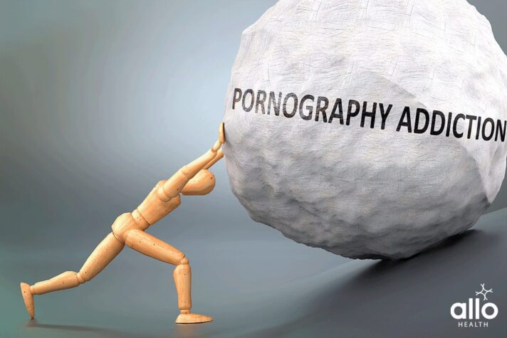 Pornography addiction and painful human condition, pictured as a wooden human figure pushing heavy weight to show how hard it can be to deal with Pornography addiction in human life. porn addiction symptoms in hindi Pornography Addiction